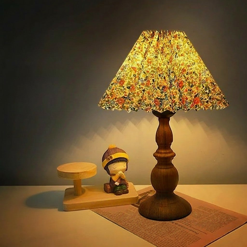 KAVYNZO bedside table lamp with a wood grain base and a pleated floral fabric lampshade emitting a warm glow.